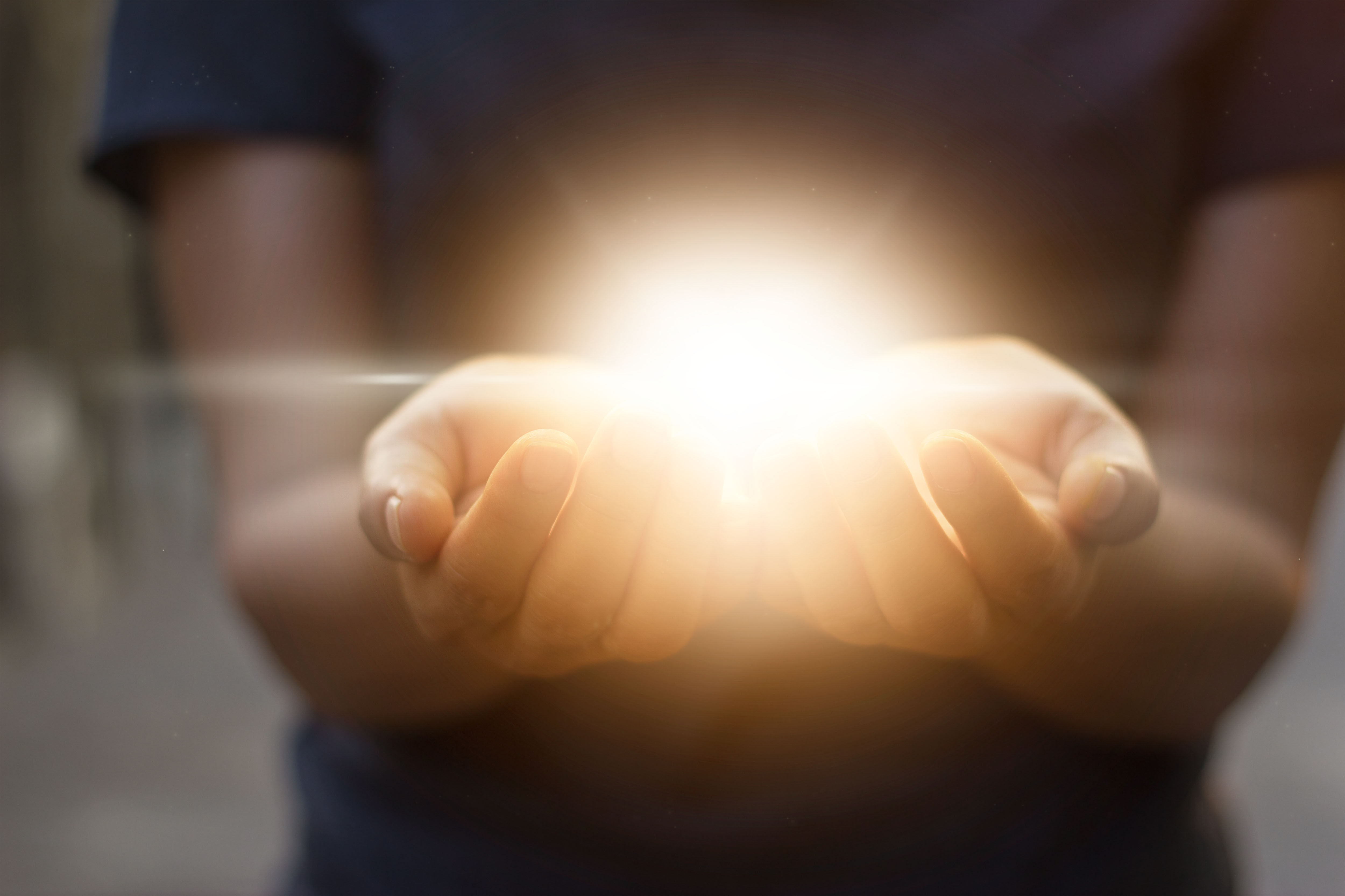 hands holding a glowing light