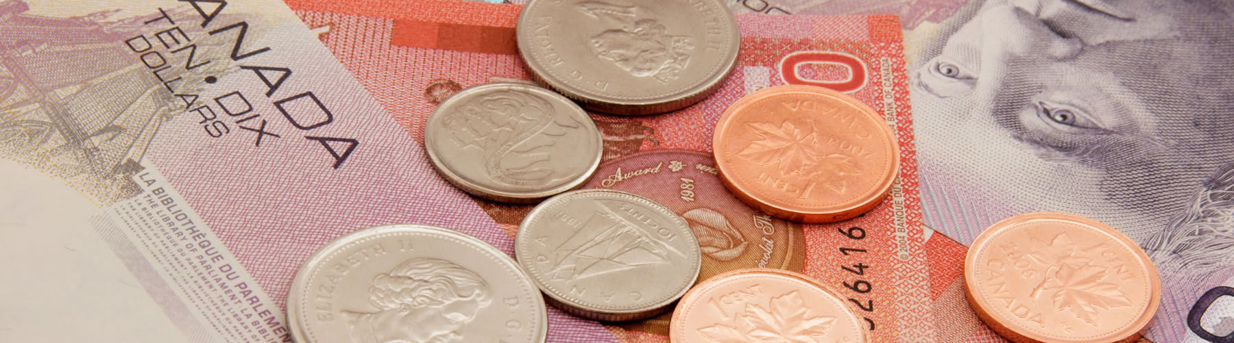 Canadian coins on top of bills